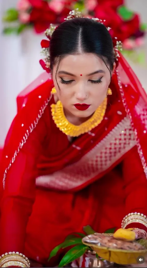 Traditional Nepali bride in red and gold with tika and jewellery