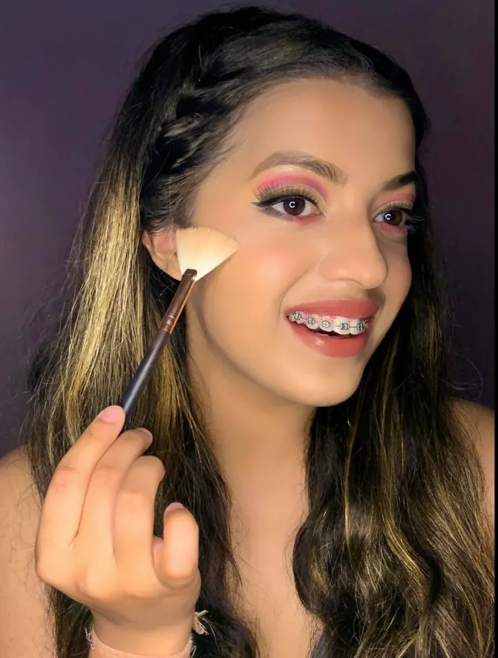 Smiling client with soft glam makeup, blush applied with a brush at Style by Saamna in Auburn