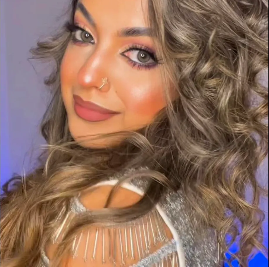 Glamorous makeup look with warm tones and bouncy curls