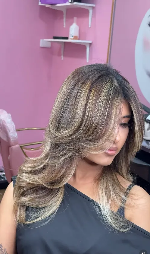 Lived-in balayage blonde with face-framing layers, styled in the salon